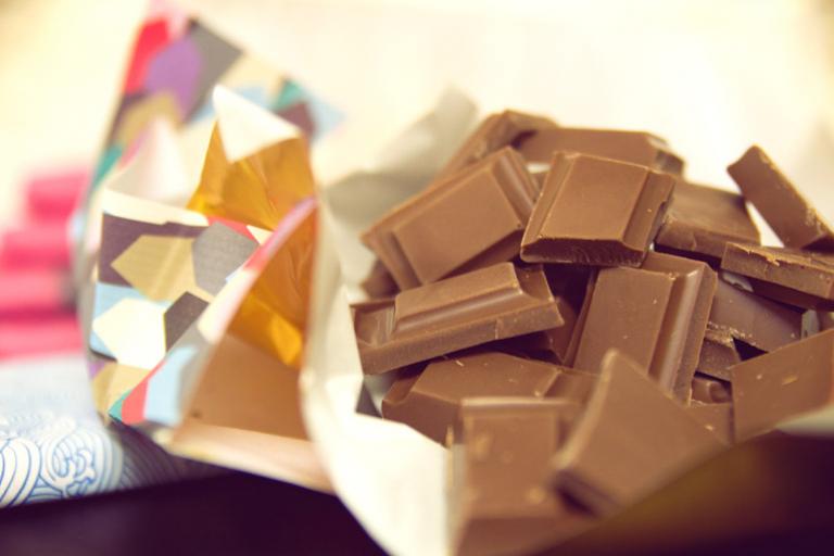 A delicious bar of dairy-free milk chocolate, broken into pieces.