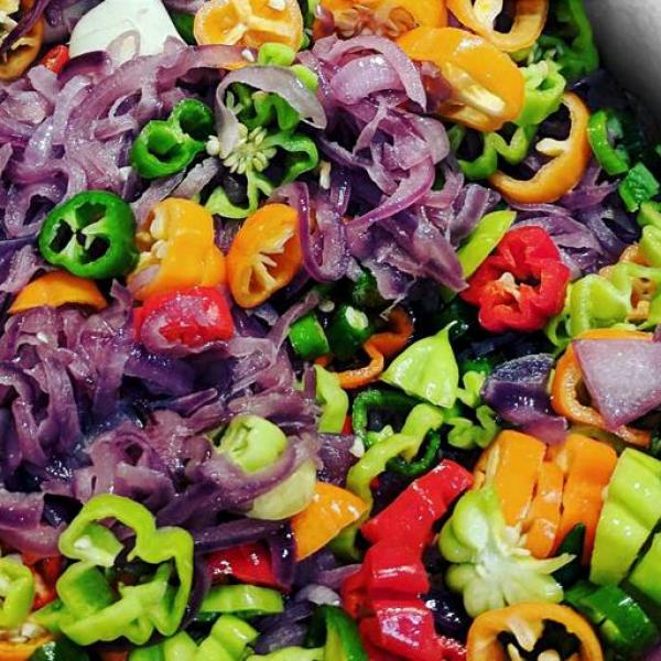 An iridescent array of chilies, onions, and garlic, slowly sweating over a low heat